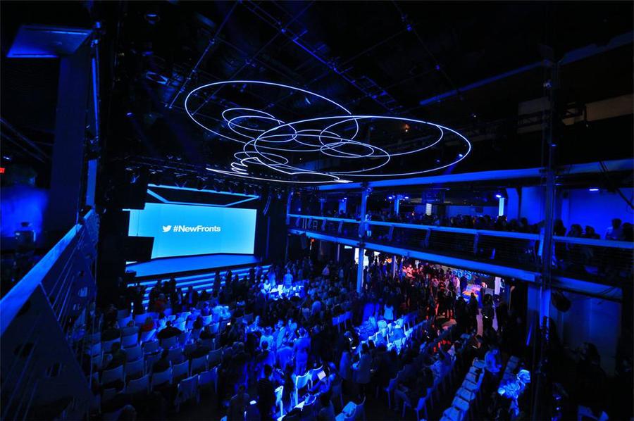 重复的logo、反光的镜子和霓虹灯的使用，强化了推介会策划的吸引力和戏剧性